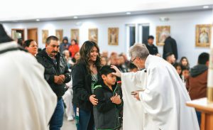 Fr. Neil blesses an immigrant child.