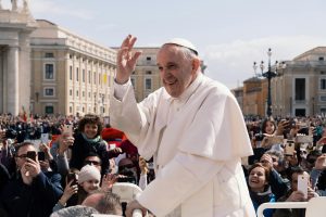 Pope Francis waves to a crowd of people.