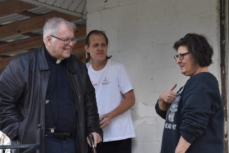 Fr. Vic visits a family's home, where he blesses their cats. He uses a whisk to improvise an aspergillum.